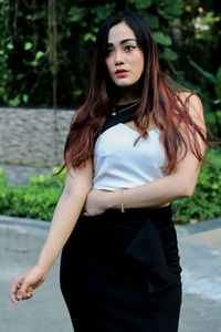 Portrait of beautiful young woman standing outdoors