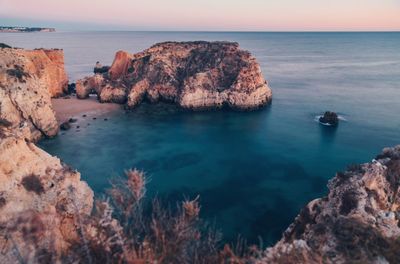 Scenic view of rocks in sea against sky