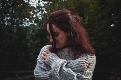 Close-up of young woman against trees