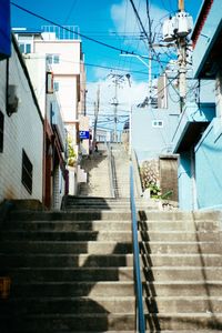 Steps amidst buildings against sky