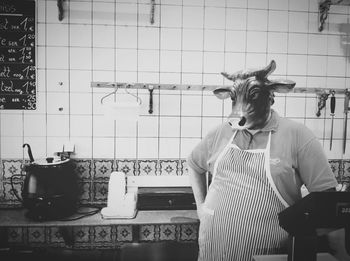 Man wearing animal mask against tiled wall