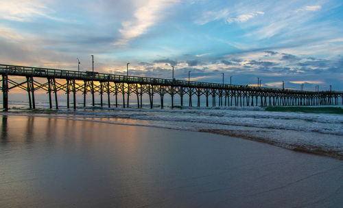 Pier over sea against sky during sunset