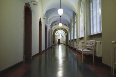 Illuminated pendant lights hanging on ceiling of corridor