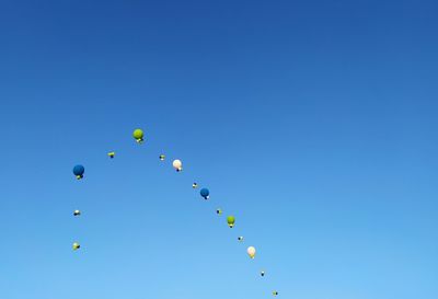 Low angle view of balloons against blue sky