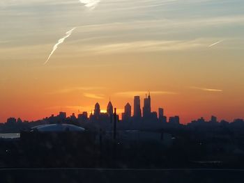 Silhouette buildings against sky during sunset