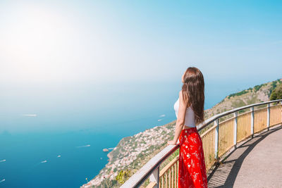 Rear view of woman looking at sea against sky