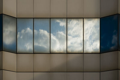 Reflection of cloudy sky on modern building