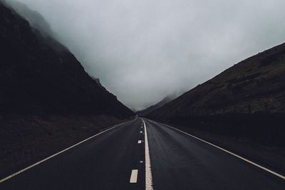 Empty road against cloudy sky