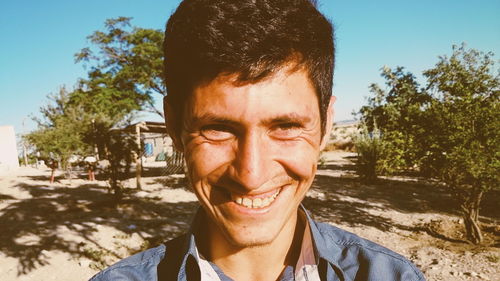 Close-up of cheerful young man with mouth open on sunny day