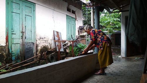 Woman standing by window of building