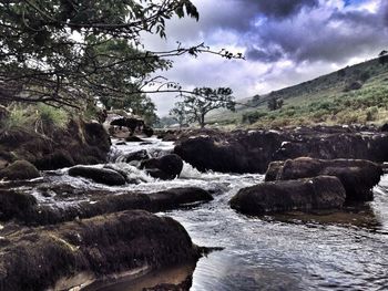 Scenic view of river against cloudy sky