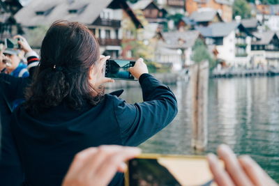 Rear view of woman photographing outdoors