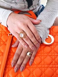 Midsection of woman with orange purse