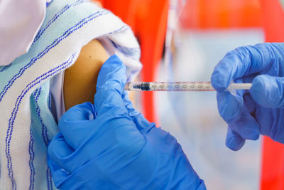 Midsection of doctor holding syringe