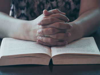 Close-up of woman reading book on table