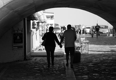 Rear view of couple walking under archway