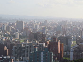 Aerial view of buildings in city against sky