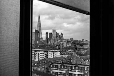 Shard london bridge amidst buildings seen through window in city