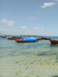 Boats moored in sea against sky