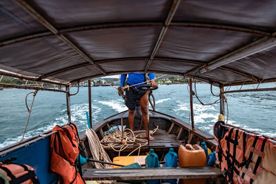 Low section of man standing in boat