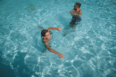 Brothers swimming in a crystal clear swimming pool