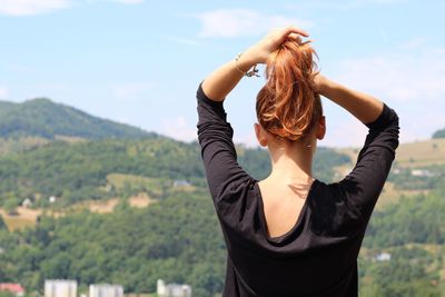 Full length of woman standing on landscape against sky