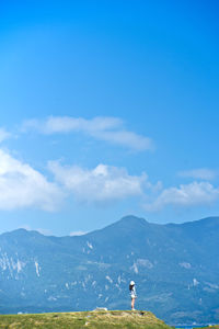 Woman standing on mountain against sky