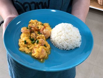 Close-up of hand holding ice cream in plate