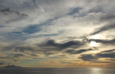 Scenic view of sea against cloudy sky at sunset