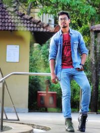 Full length of young man standing against wall