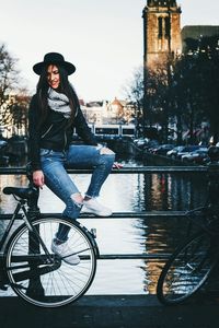 Portrait of smiling woman sitting on bicycle in city
