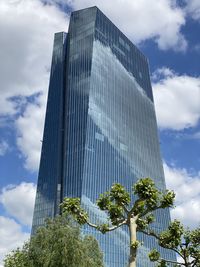 Low angle view of modern building against cloudy sky