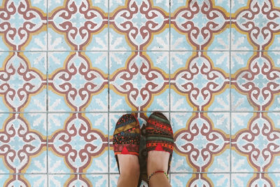 Low section of woman standing on tiled floor