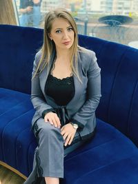 Portrait of beautiful woman sitting on sofa in cafe