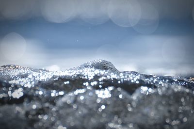 Close-up of bubbles against sky on sunny day