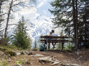 Couple sitting on bench and looking at mountains