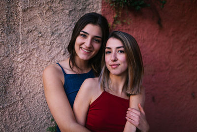 Portrait of lesbian couple standing against wall