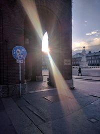 Street light in city against sky during sunset