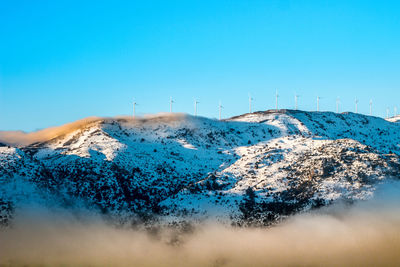 Scenic view of snowcapped mountains against clear blue sky