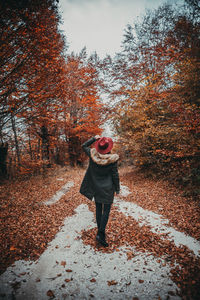 Full length of woman standing on street during autumn