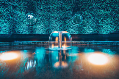 Fountain against plant at night