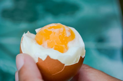 Close-up of hand holding a boiled egg 