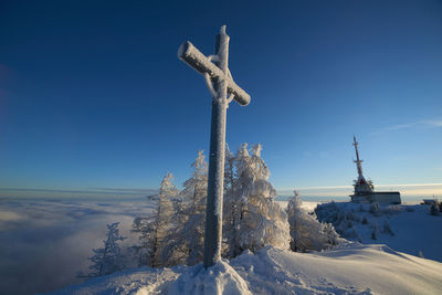 Snow covered land against blue sky