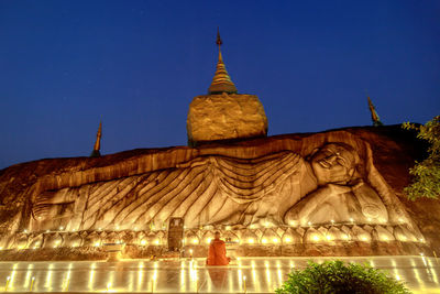 Statue of illuminated building against clear sky