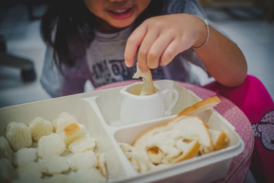 Midsection of woman holding ice cream on table