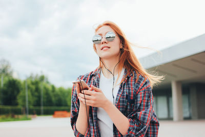 Young woman wearing sunglasses standing outdoors