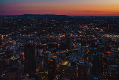 Aerial view of city lit up at sunset