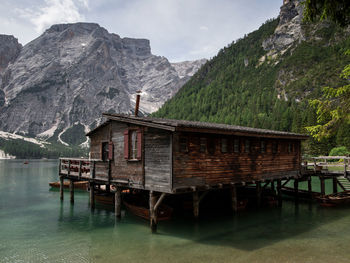 Built structure by lake and mountains against sky