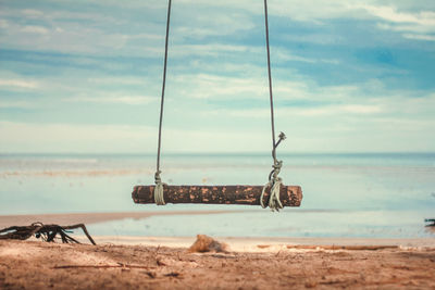 View of swing on beach against sky