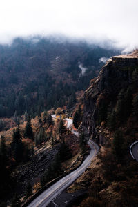 High angle view of road by mountain against sky during foggy weather